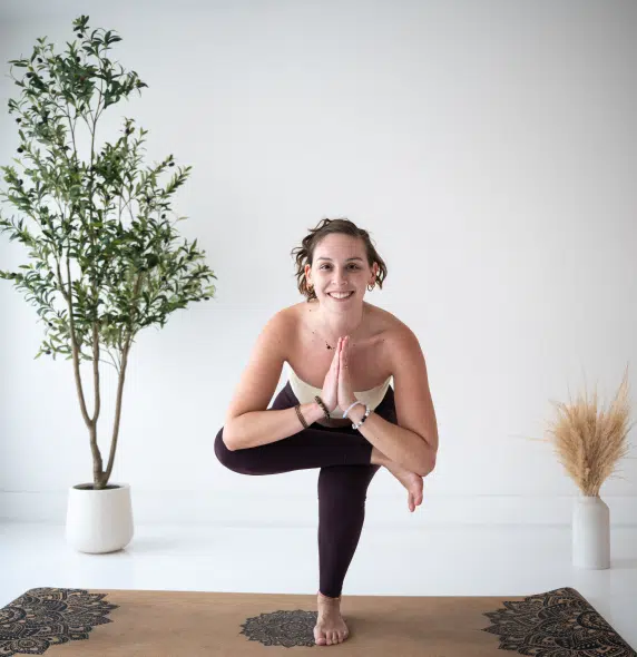 Woman doing private yoga session on a mat outdoors